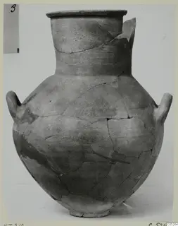 Two-handled jar of Cypro-Hell.I pottery, reconstructed from broken pieces and photographed against a pale backdrop.