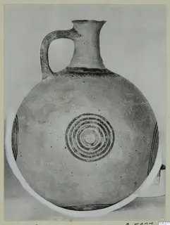 Pottery White Painted I jug with a strap handle and concentric rings on its round body