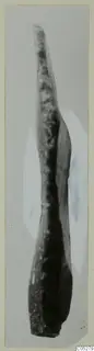 Long narrow stone object tapering to a point at the top, photographed upright at Kythrea