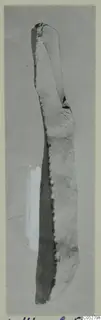 Elongated stone object from Kythrea, shown upright on a grey card mount.