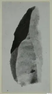 Stone object from Kythrea: an elongated fragment, dark on one side and pale grey on the other