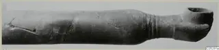 Red Lustrous Ware vessel with a long body and wide flared mouth, photographed lying horizontally, from Ayios Iakovos