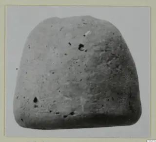 Grey block-shaped find from the Vrysi tou Barba tombs at Lapithos, photographed on a card mount