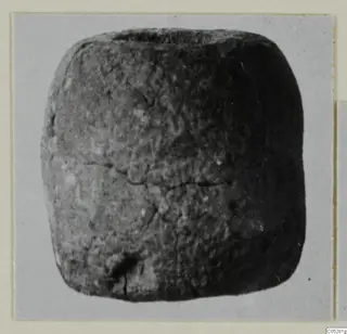 Small dark object with rounded corners, from the Vrysi tou Barba tombs at Lapithos