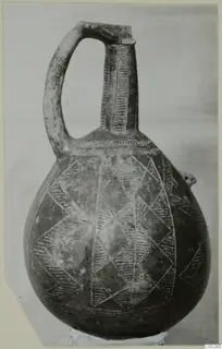 Red Polished II jug with a curved handle and incised chevron and hatched decoration, standing on a support