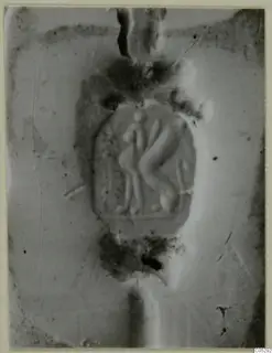 Glyptic object with two figures carved in relief at its centre, close view