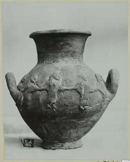 Two-handled pottery jar with relief figures of animals on its body, photographed against a plain backdrop