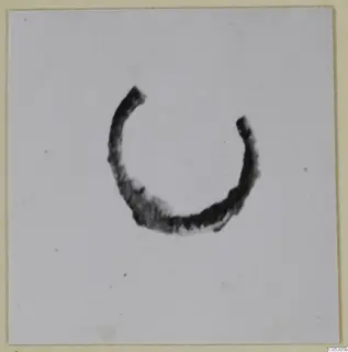 Open ring of bronze, a piece of personal adornment, photographed alone on a pale ground.