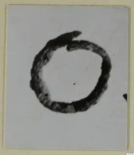 Close photograph of a bronze ring-shaped personal adornment from Lapithos on a pale background