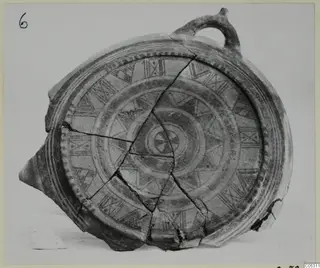 Pottery Bichrome II vessel with a loop handle, reassembled from broken sherds and painted with patterned bands
