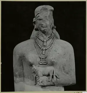 Limestone statue bust with a beaded necklace and a small sculpted animal at its chest.