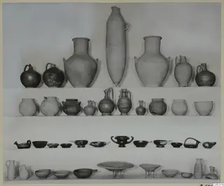 Pottery vessels from Marion, Tomb 39: jugs and bowls arranged in rows on shelves.