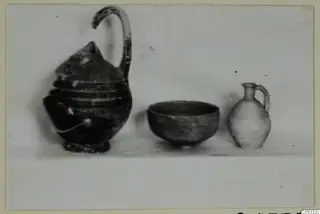 Pottery from Marion Tomb 24: a jug, a bowl and a small juglet standing side by side on a pale surface.