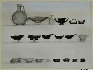 Pottery from Tomb 36 at Marion: jugs, bowls, a juglet, cups and small lamps arranged in three rows