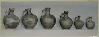 Six small pottery jugs with single handles, in a row from large to small, from Marion Tomb 48.