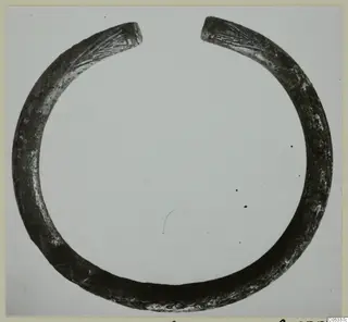 Open metal ring with tapering ends, the ends marked with incised lines, from Marion