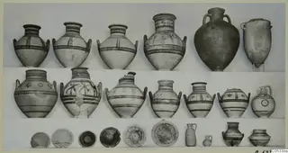 Rows of painted jars, bowls and small vessels from Marion, Tomb 84, photographed on a light background.