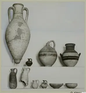 Several pottery vessels from Marion, Tomb 74, set out on a plain background, including a large two-handled amphora and banded jugs.