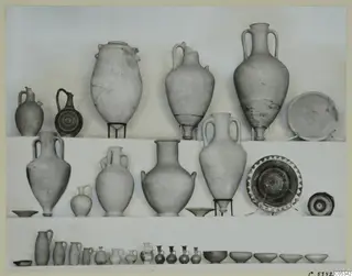 Pottery from Marion, Tomb 72: jugs, jars and bowls arranged in three rows against a plain backdrop.