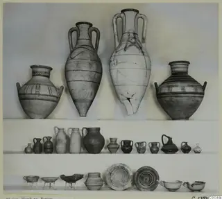 Pottery from Marion Tomb 73 arranged on three shelves: large two-handled jars, small jugs and jars, and bowls.