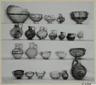 Pottery from Tomb 63 at Marion: about twenty vessels, jugs, bowls and juglets, set out in four rows.