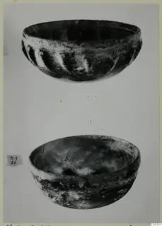 Two cast glass bowls, one with vertical ribbing on its outer wall and one plain, shown one above the other
