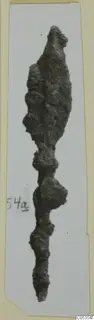 Heavily corroded metal weapon with a leaf-shaped blade and narrow tang, mounted on a card for photographing.