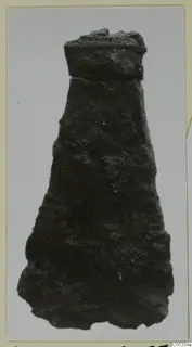 Corroded iron tool, tapering from a squared top to a wide, irregular lower end