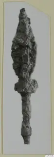 Corroded iron weapon with a leaf-shaped point, a collar and a long tapering shank, shown on a card mount