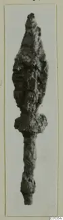 Corroded iron weapon with a leaf-shaped blade, a shoulder and a long narrow tang.