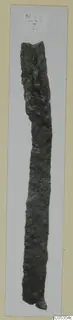 Corroded iron knife, long and narrow, photographed upright on a light card mount