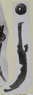 Corroded iron strigil and a small round object with a hole, from Marion tomb finds