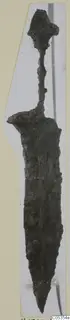 Corroded iron weapon with a knobbed pommel and long tapering blade, point downward.