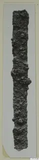 Long, narrow corroded iron object from Marion, photographed upright on a card mount