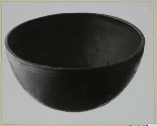 Dark, smooth-walled bowl with a rounded body and a thickened rim.