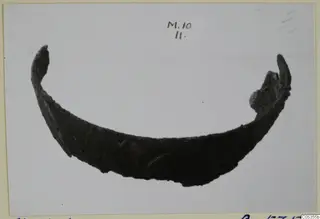 Curved dark fragment of a bowl from Marion, shown on a mounted photo card