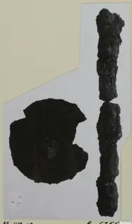 Two corroded iron fragments on a photo mount: a rounded piece with a notch and a long rod in two pieces