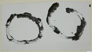 Two corroded rings, one nearly closed and one open, on a pale background; find from Vouni