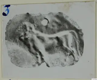 Fragment of a gold jewellery piece from Vouni, with a raised figure in relief and a small round hole