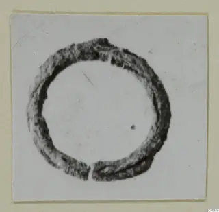 Dark ring-shaped piece of jewellery from Amathus, mounted on a card for photographing