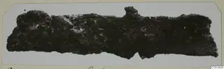 Corroded iron tool from Amathus: a long, broken fragment with a knob-like projection on its upper edge