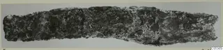 Corroded iron tool from Amathus, long and flat, with a pitted dark surface and pale encrustation.