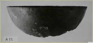 Dark bowl with a wide, rounded body and flat rim, photographed from the side against a pale background, from Amathus