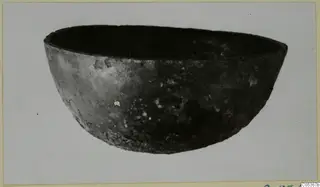 Dark, rounded bowl with a wide open rim, shown on a plain background