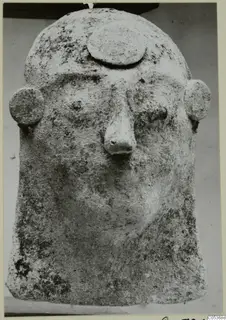 Protome in the form of a human head, with a flat disc on the brow and round ears, from Amathus