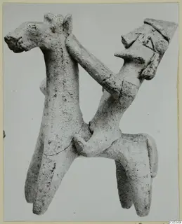 Terracotta figurine of a four-legged animal with a small human figure whose arm reaches over its neck