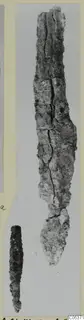 Two corroded iron objects, one long and tapering, from Amathus tombs 10–26, shown on a photo mount