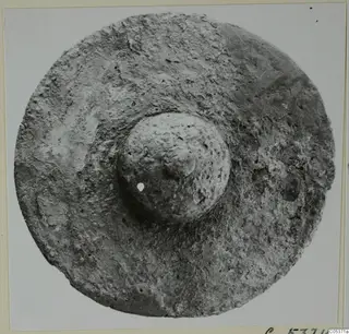 Round object with a central domed boss pierced by a small hole, from Amathus.