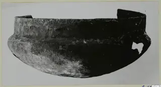Bowl fragment with a broken rim and a gap in its lower right side, shown upright on a pale background.