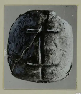 Glyptic from Amathus: a flat, rounded stone seal with a cross-shaped pattern of pale lines.